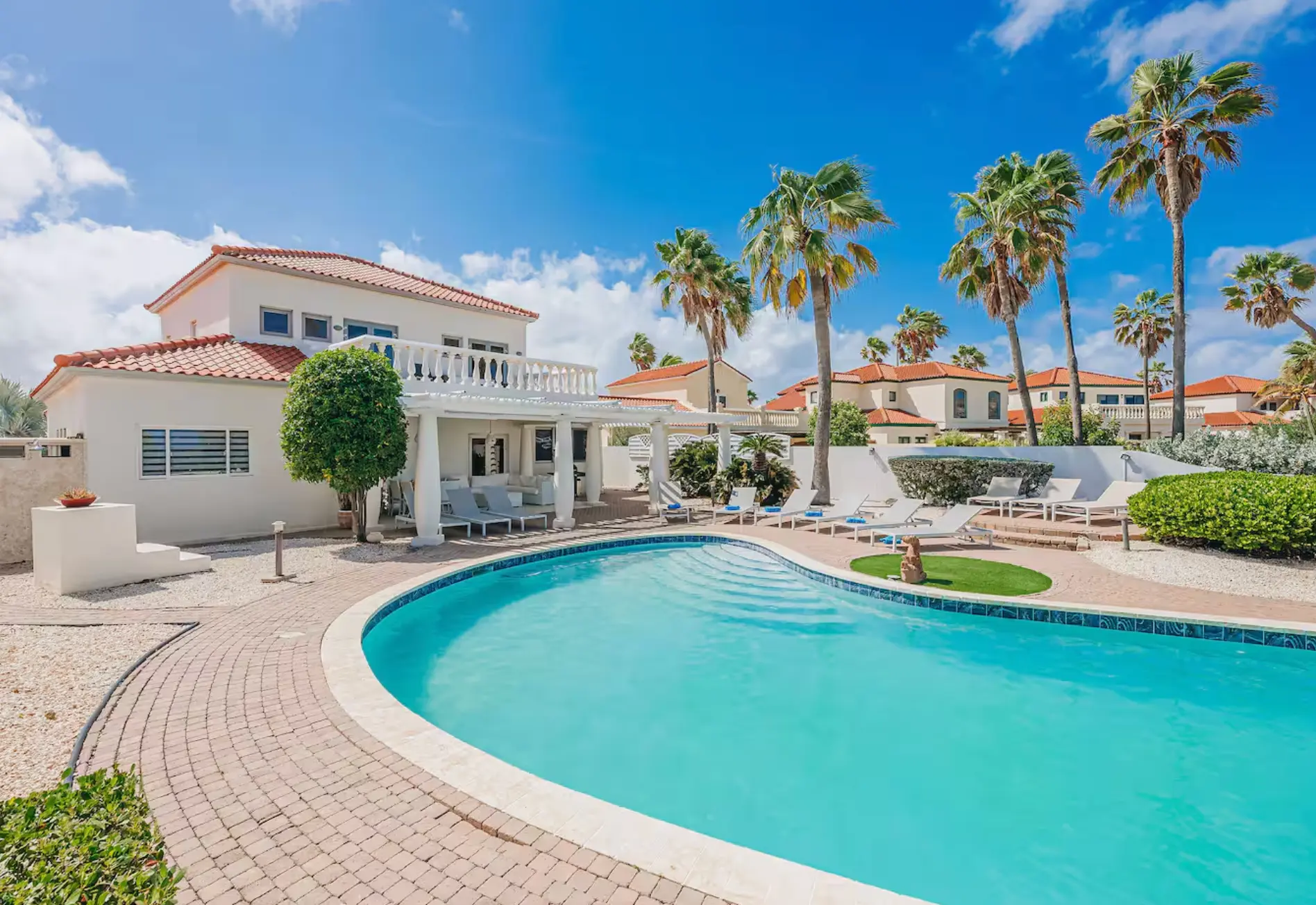 Villa pool deck with loungers and shaded terrace