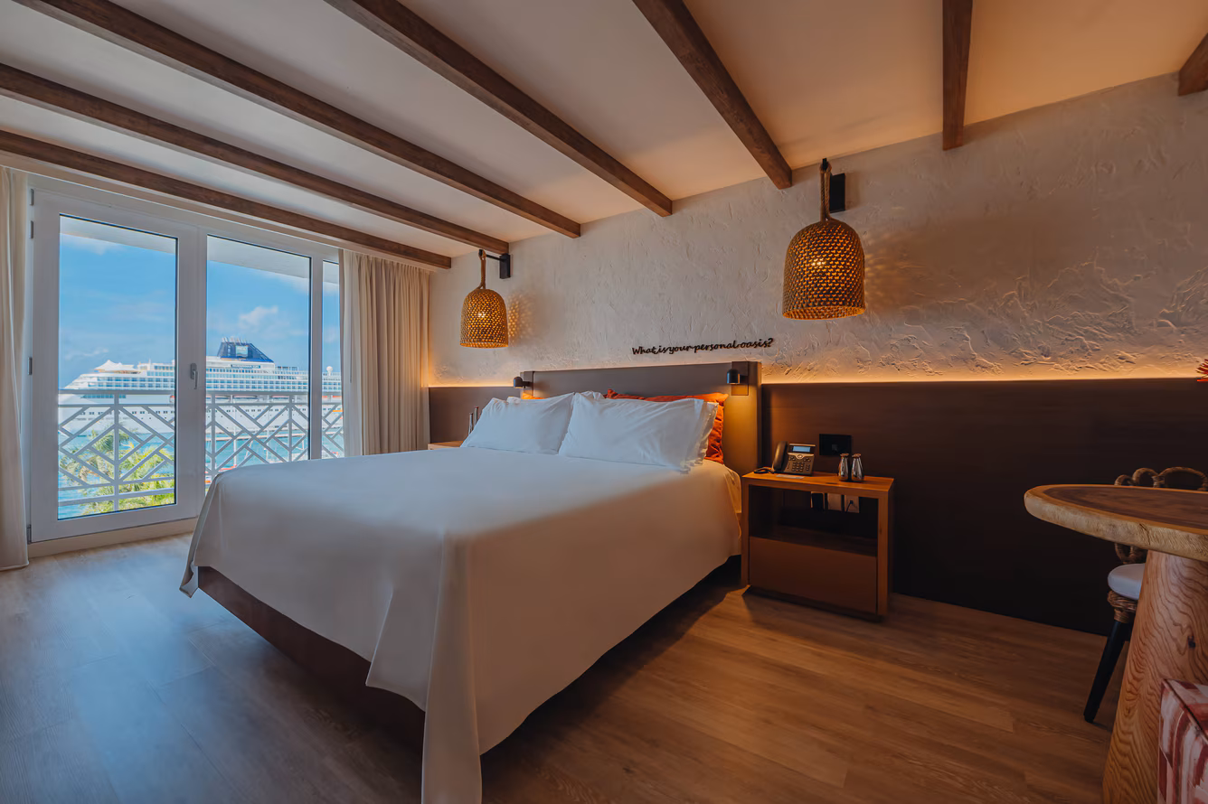 King ocean-view suite with floor-to-ceiling windows opening onto the Caribbean