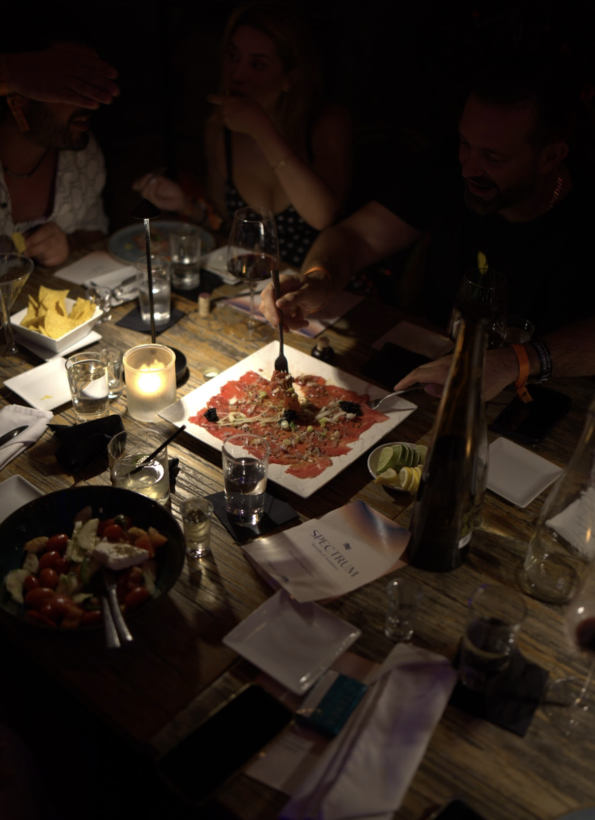 Overhead view of a shared carpaccio with a Spectrum menu on the table