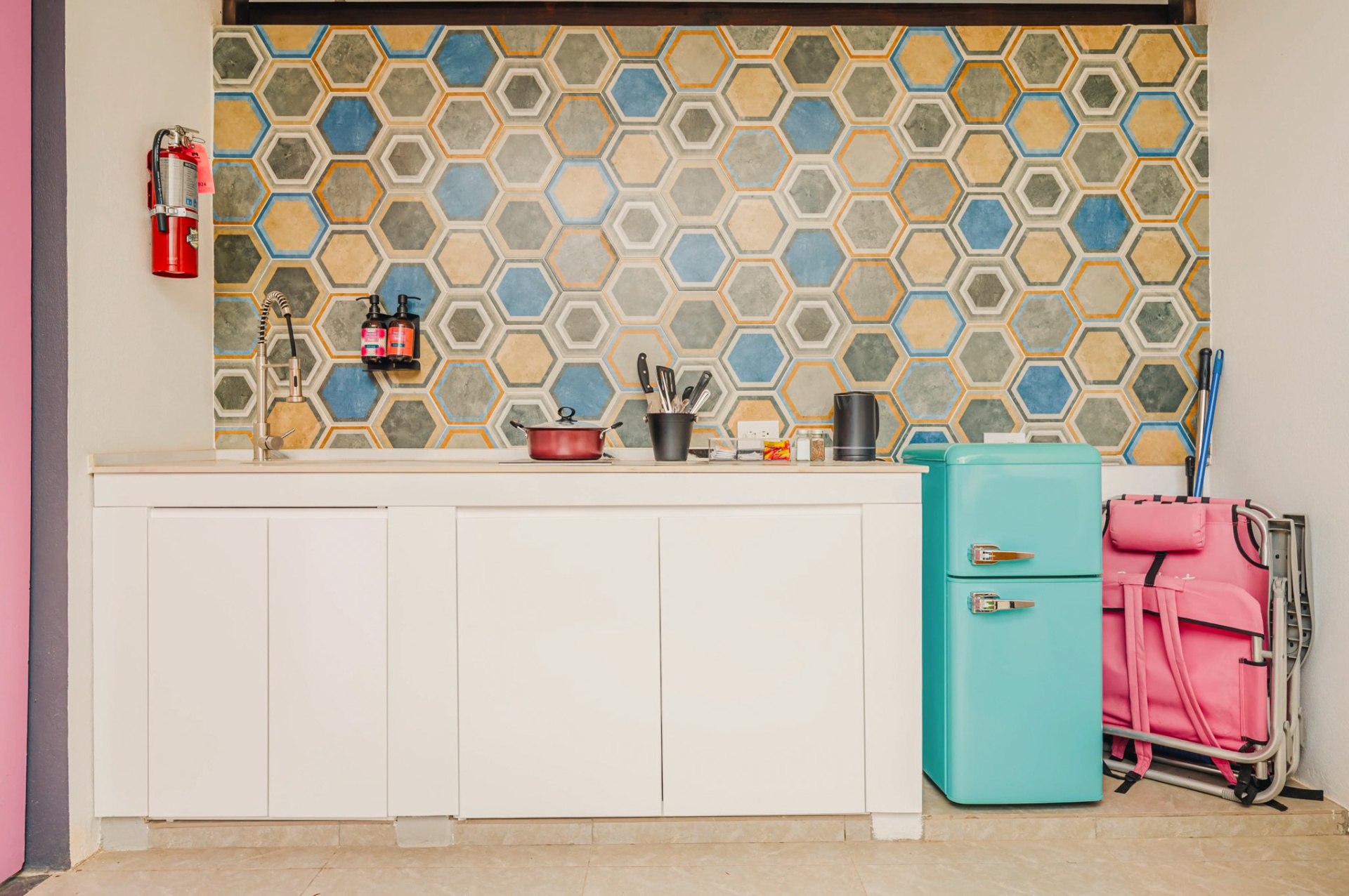 Outdoor kitchenette with hexagonal tile backsplash and mint retro fridge