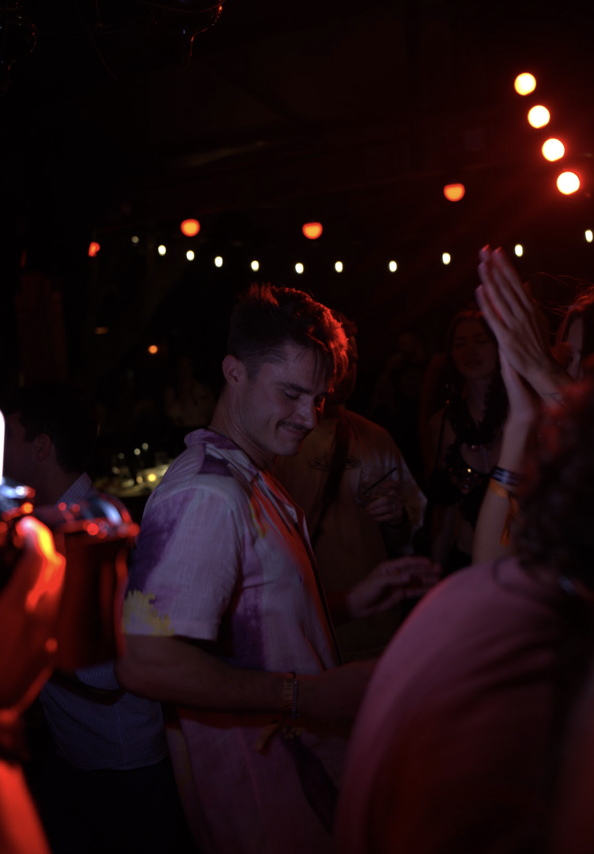 A guest dances under warm string lights
