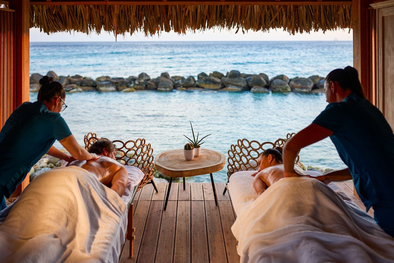 Two oceanfront massage tables under a palapa overlooking the Caribbean