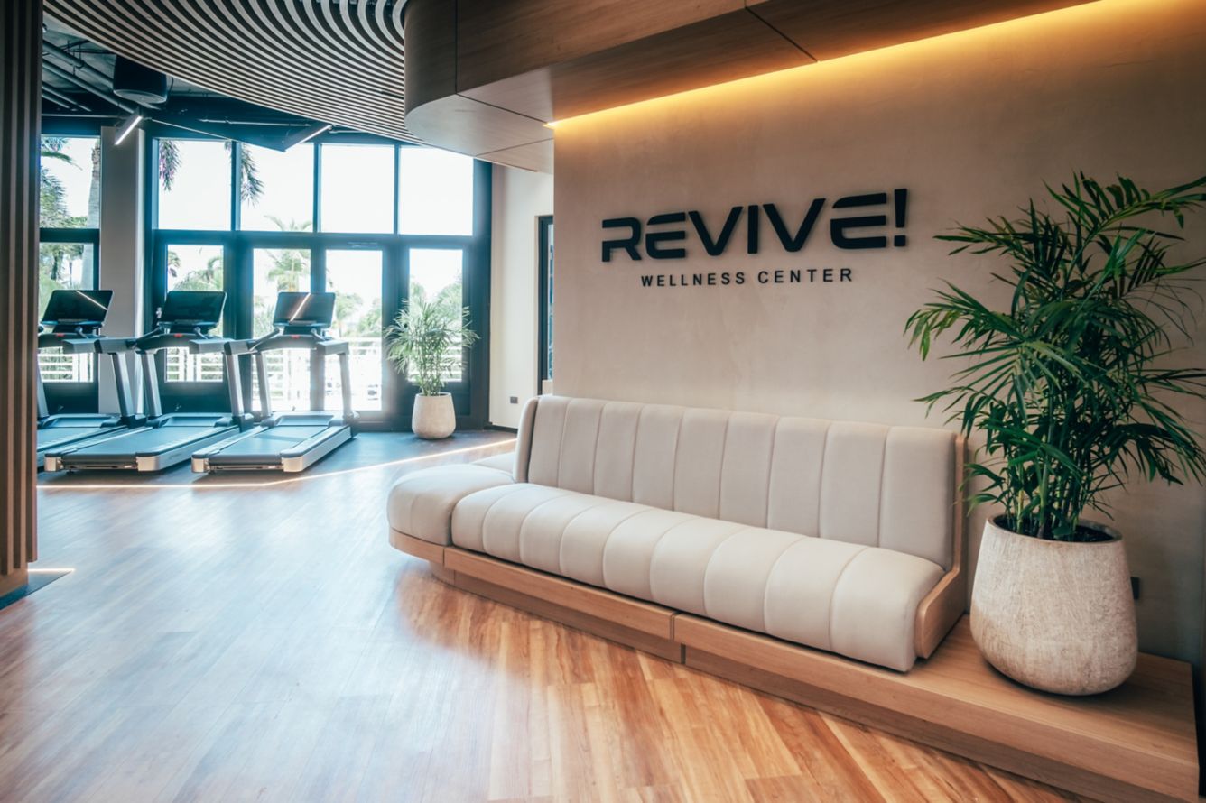 Revive Wellness Center lobby with sculpted bench, treadmills and floor-to-ceiling windows