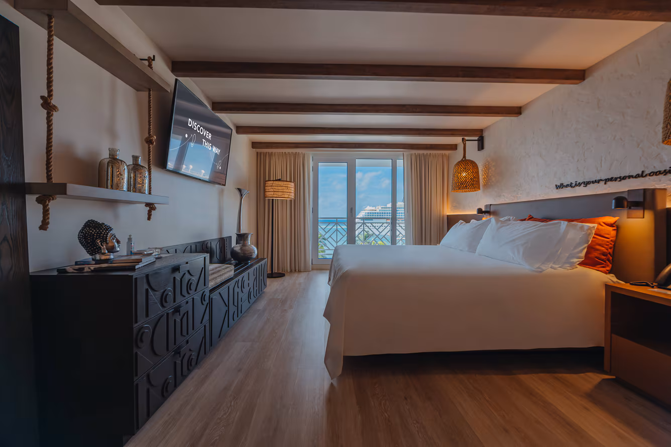 King bed dressed in white linen with marina view beyond