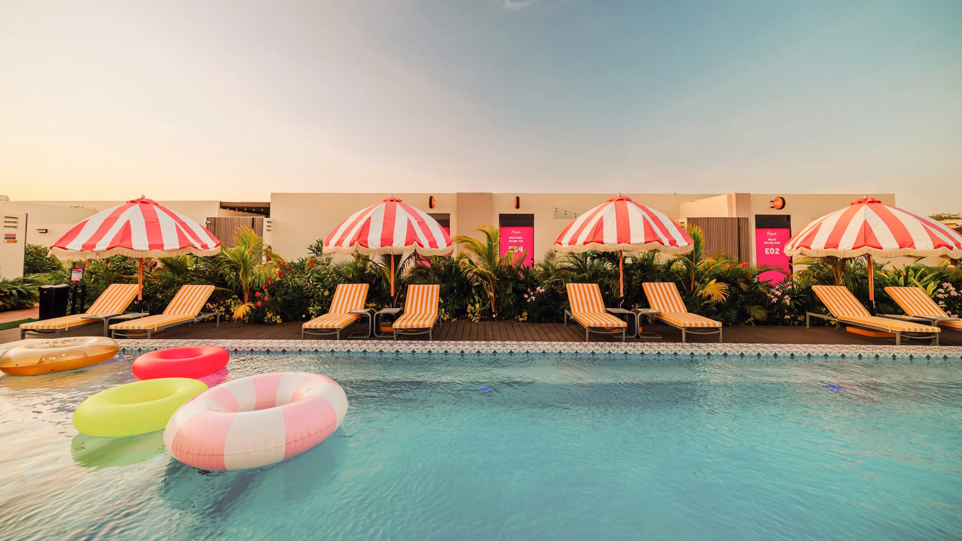 Row of striped cabana umbrellas and loungers beside the Privada pool